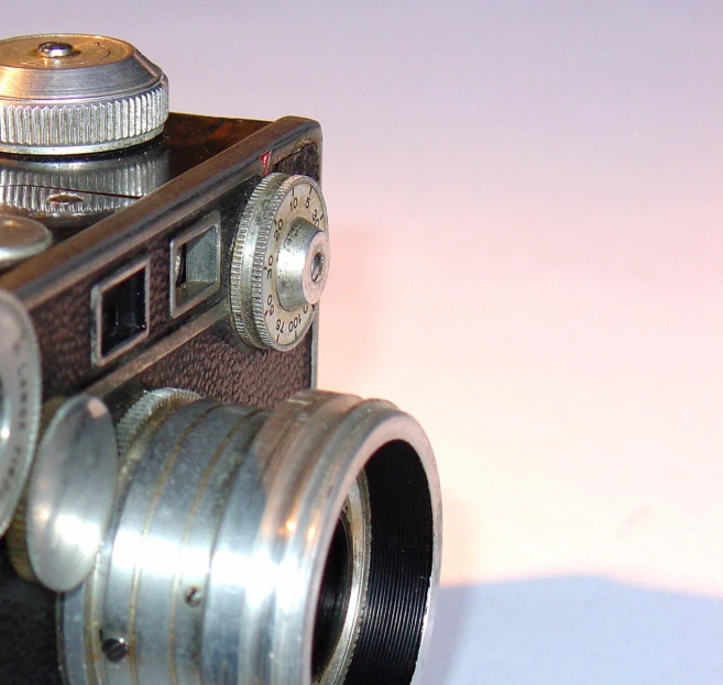 a close up of an old camera on a white table