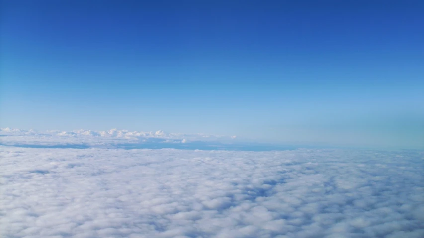 the view out an airplane window looking into some clouds