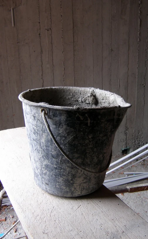 an old bucket with ropes in it sitting on the table