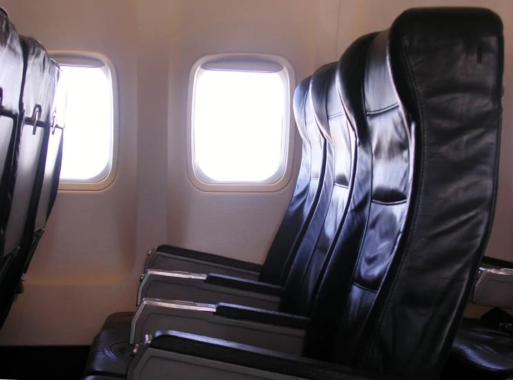 two chairs sit in front of a window on an airplane