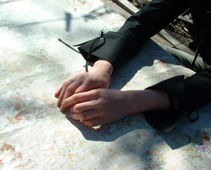 a person is sitting on the ground and holding onto a piece of fabric