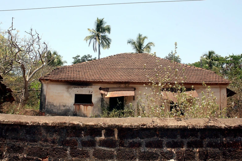 a brick building with palm trees and bushes