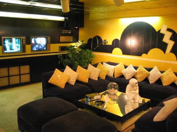 a black couch and two yellow and white pillows