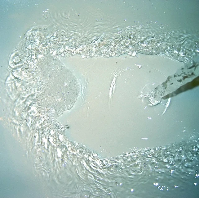 water is flowing in a bowl with a handle