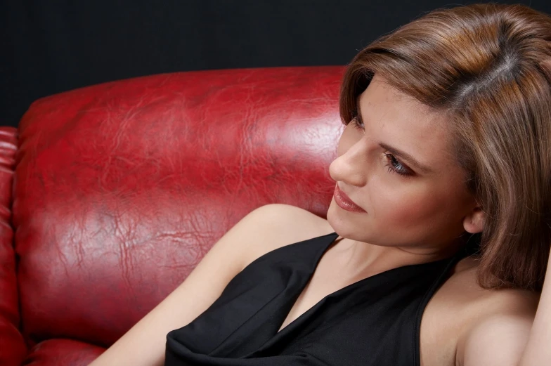 a woman with her back to the camera posing on a red chair