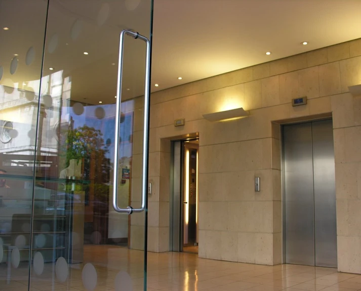 an empty lobby with three elevators and a sign for the el