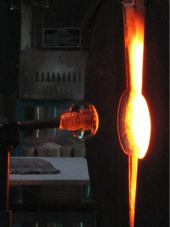 a man pouring soing into a cup with a torch