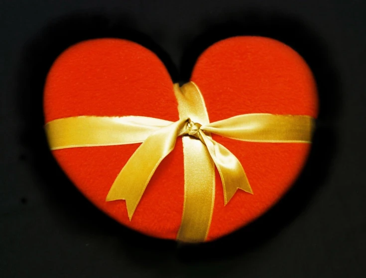 there is a heart with gold ribbon around it
