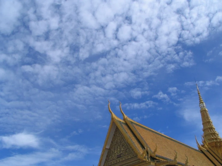 a temple sits beneath a cloudy blue sky