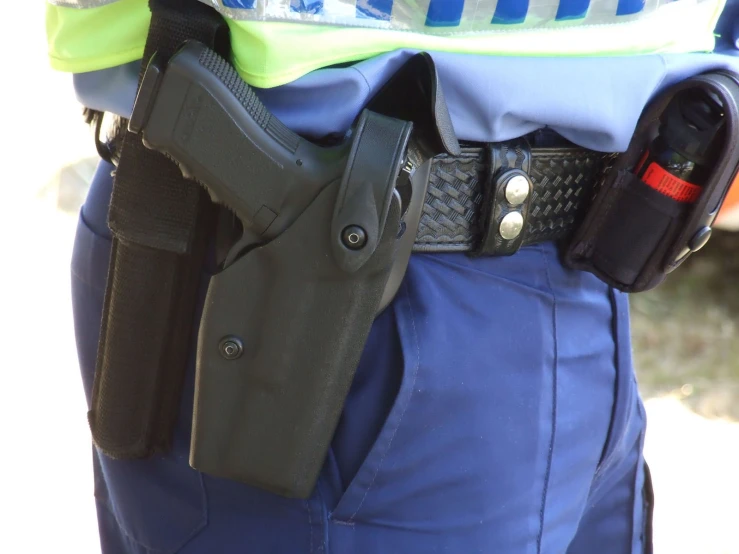 a police officer is displaying his holsters