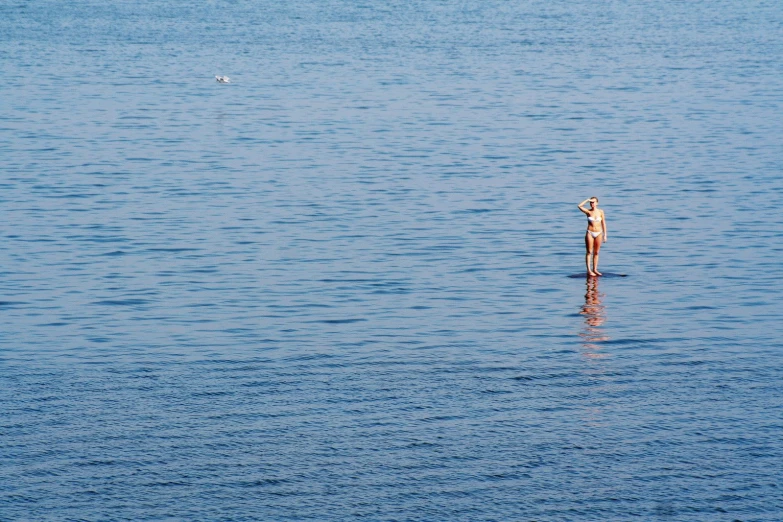 a person standing on the water in the middle of a body of water