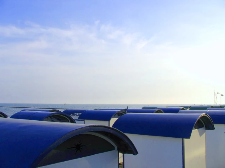 several different colored mail boxes that are next to the ocean