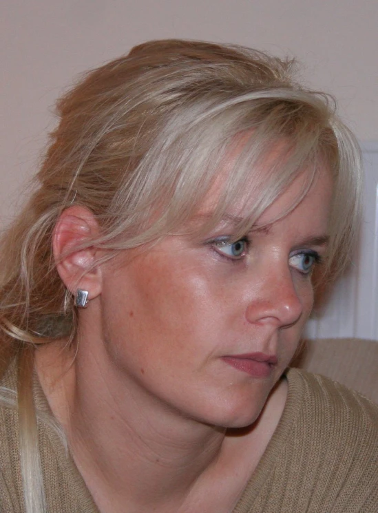 a woman with ear piercings is looking into the camera