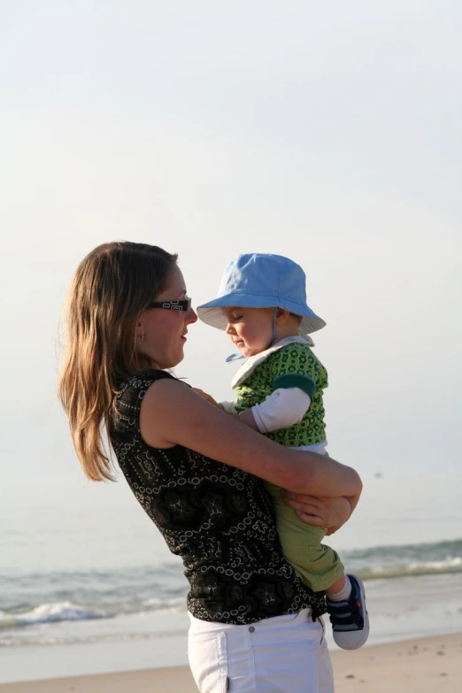 a mother holding her son at the beach