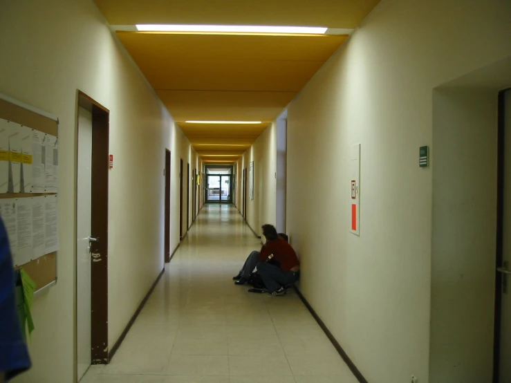 two people sitting in hallway between el rooms