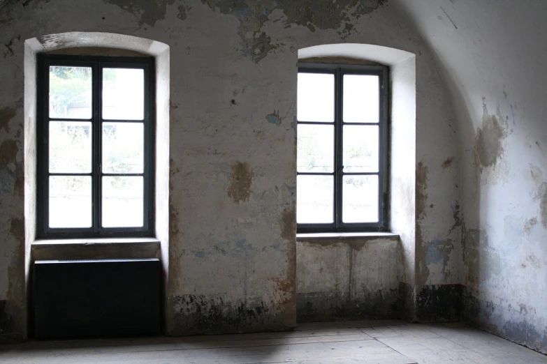 two windows in an old, run down building