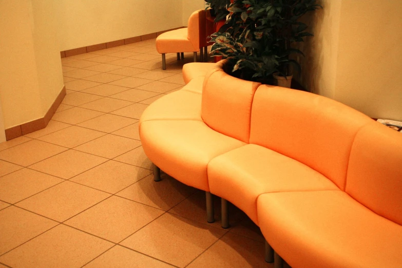 a line of orange seating in a room