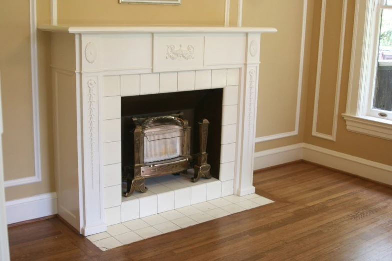 an antique fireplace with two large white tiles