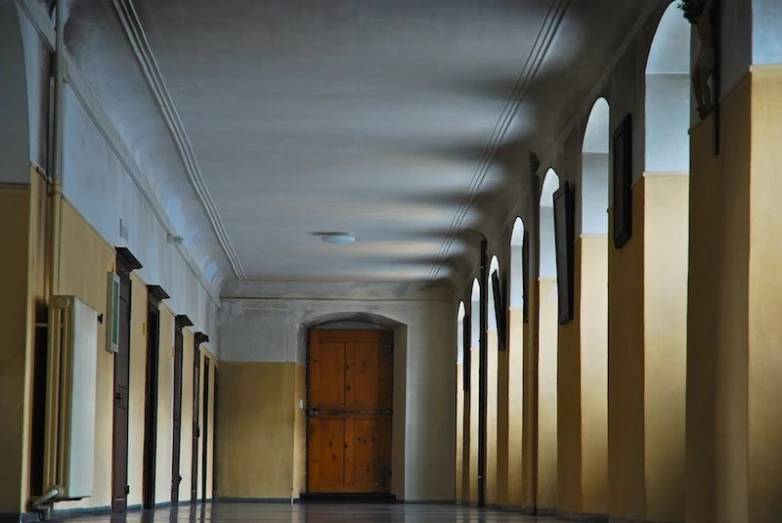 a long hallway with multiple windows leading to several doors