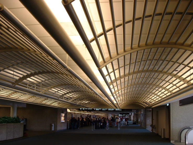 people are gathered in the walkway inside of a building