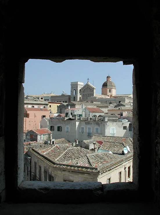 an open window into a city with roofs