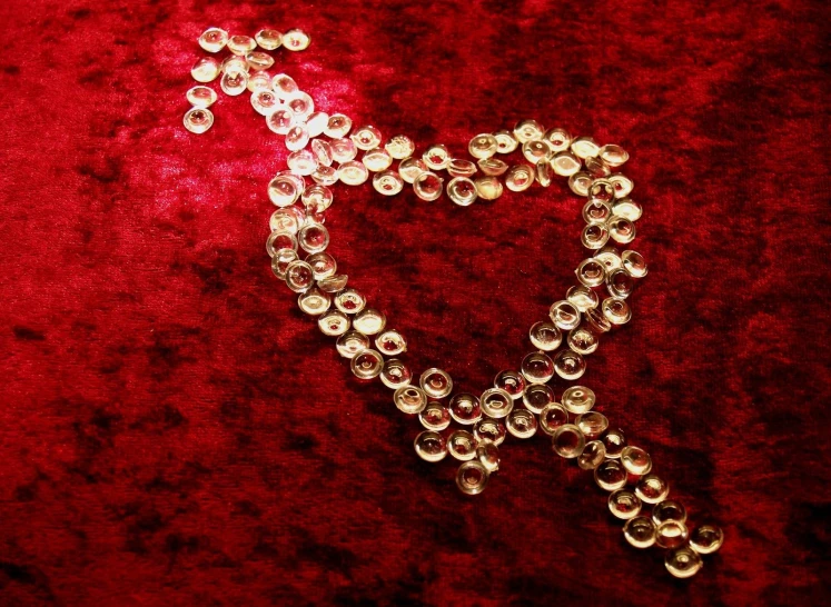 a closeup of a heart shaped brooch laying on a velvet surface