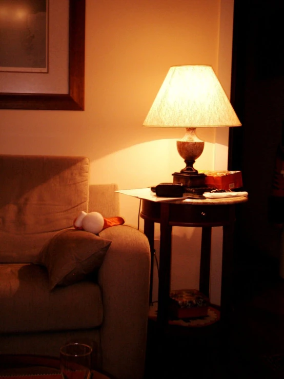 a lamp in a dimly lit room with a brown chair