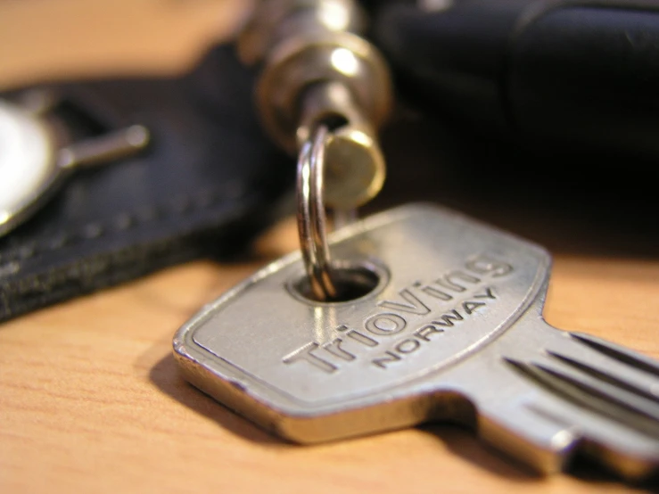 a pair of keys sitting on top of a wooden table