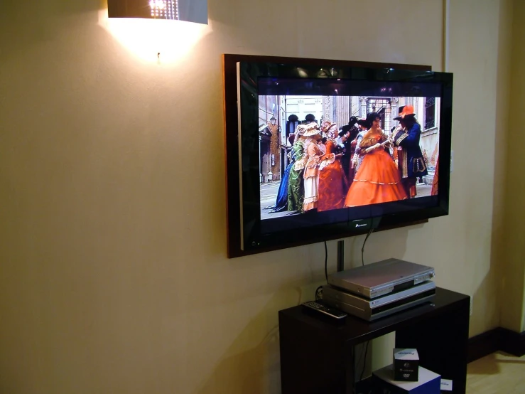 the television is displaying the show which features orange dresses