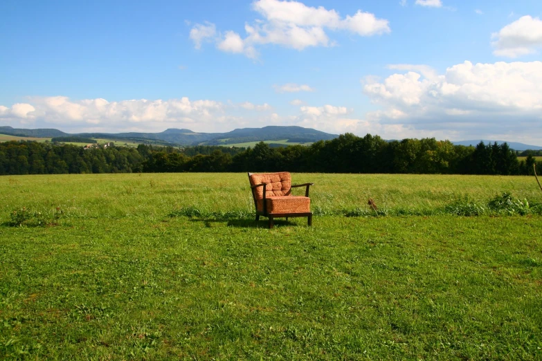 a red chair sitting in a field of green grass