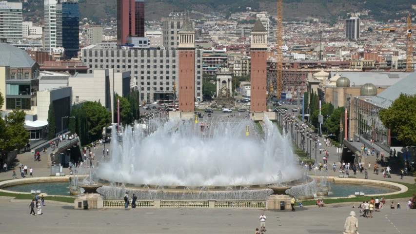 the people are around a fountain in a park