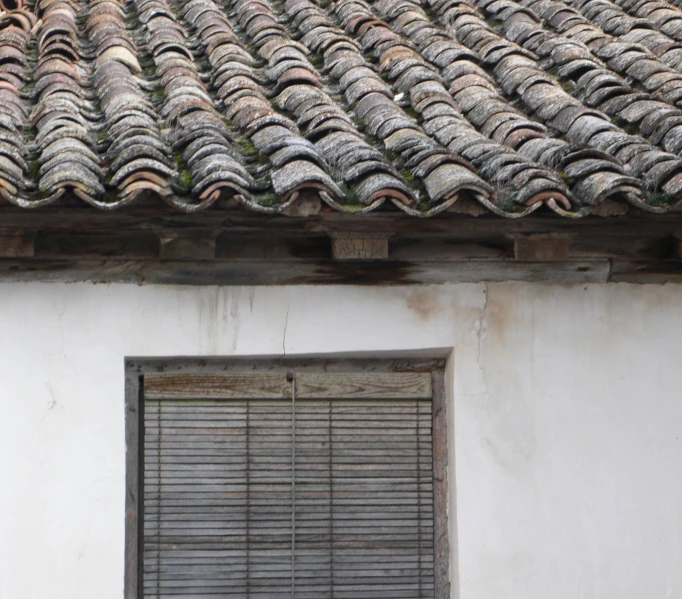 closed window with metal bars on roof with wooden shutters