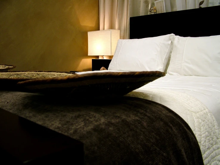 a bed with two pillows and a table with a lamp