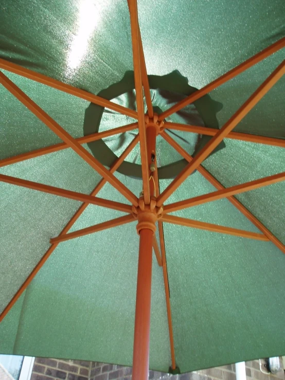 there is a green and orange umbrella on the beach