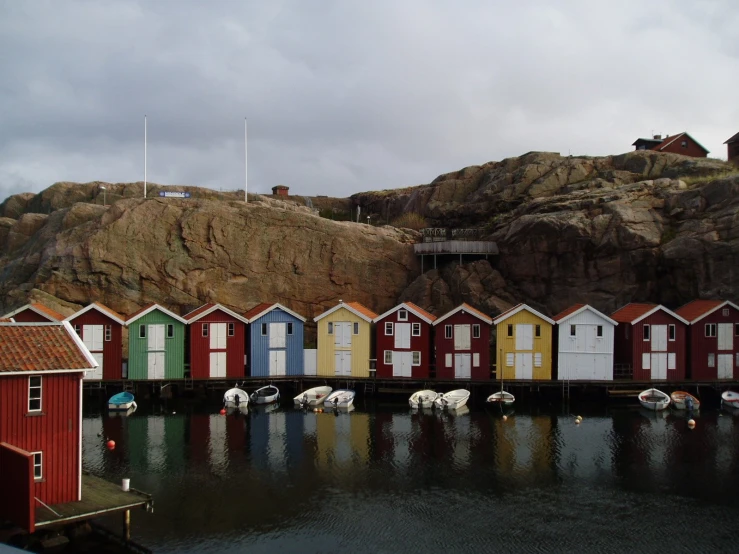 the buildings along the water line the side of a mountain