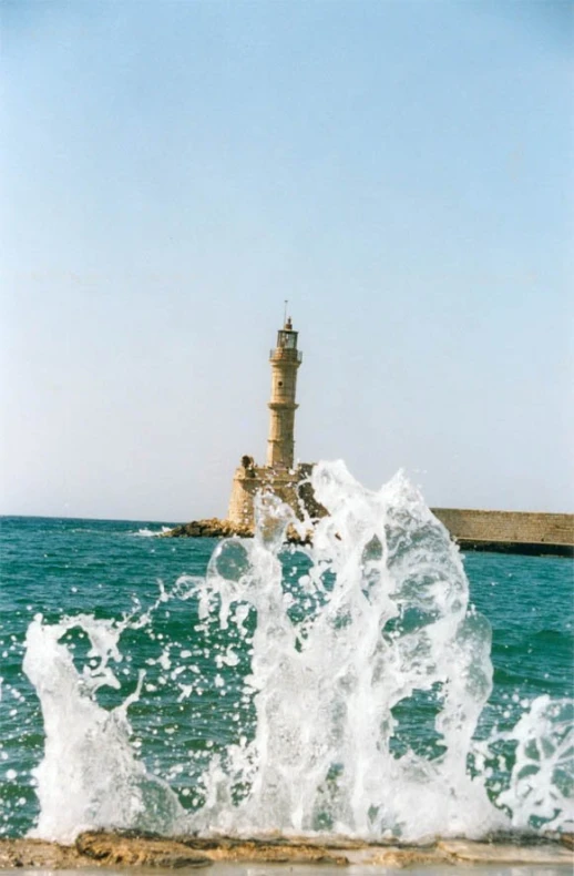 large rough ocean waves near a lighthouse