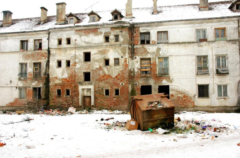 an old rusted building with broken windows covered in snow