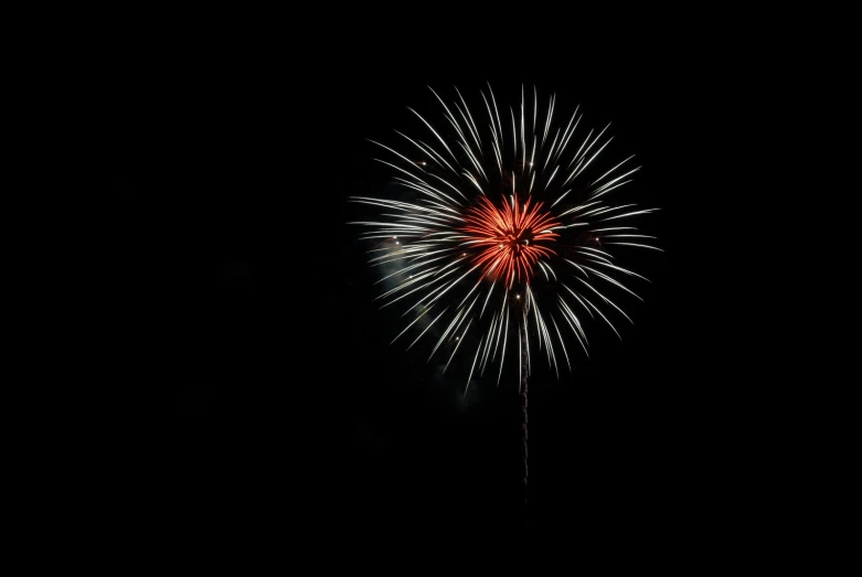 a large fireworks with red lights is lit up in the dark sky