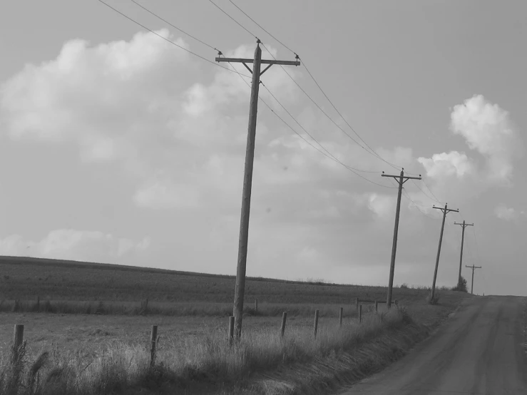 a black and white po of telephone poles in an empty road