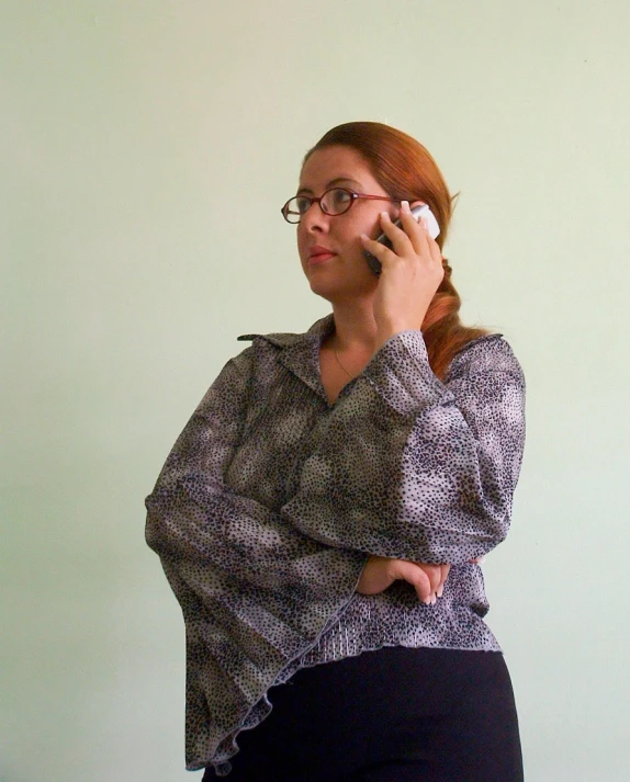 a lady holding a cell phone and talking on her other hand