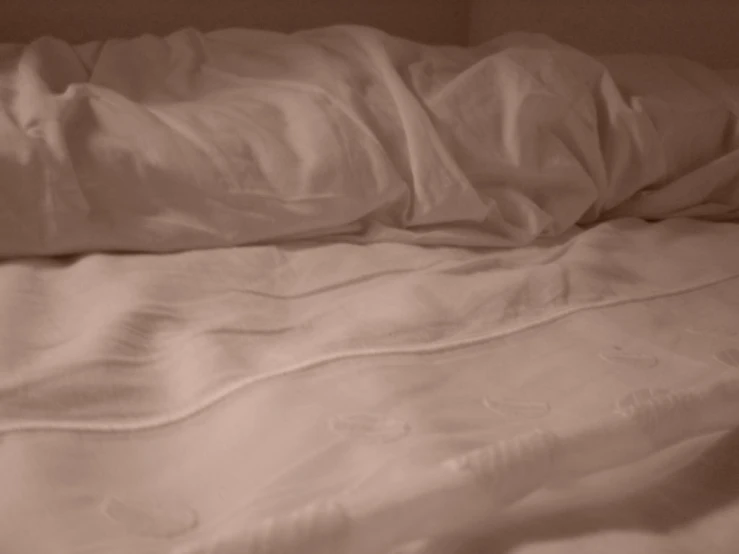 an unmade bed is shown with a white sheet and white sheets