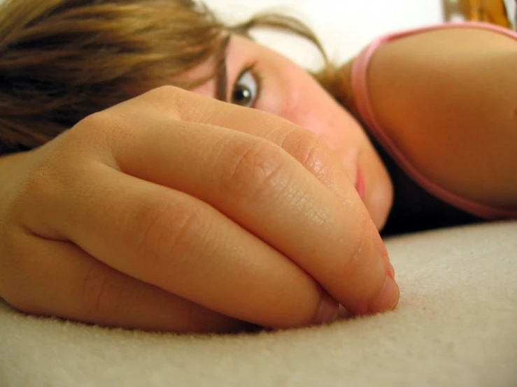 a girl laying down in a pink  looking up at the camera