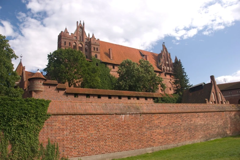 a brick fence surrounds an old brick castle
