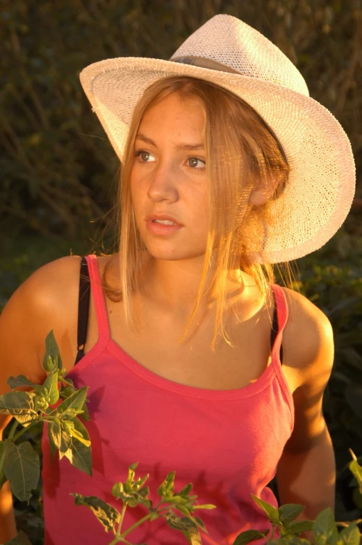 a girl is standing among the trees in the sunlight