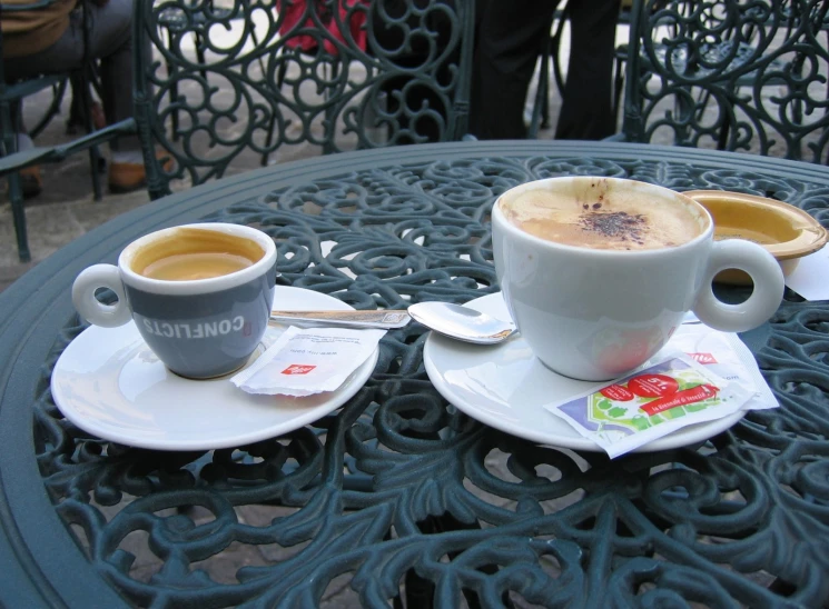 two cups on a table filled with coffee