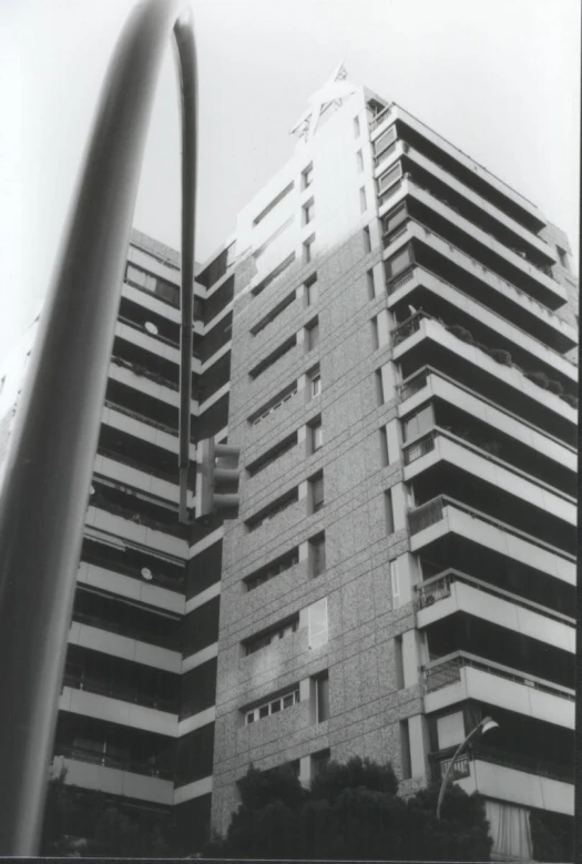 a tall building with windows and balconies next to a street light