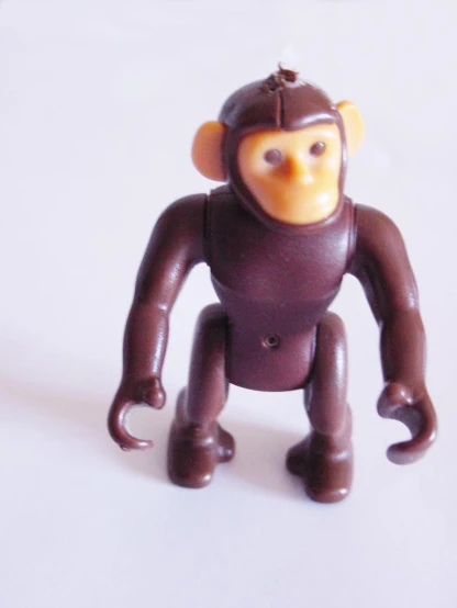 a monkey toy sitting in the middle of a white background