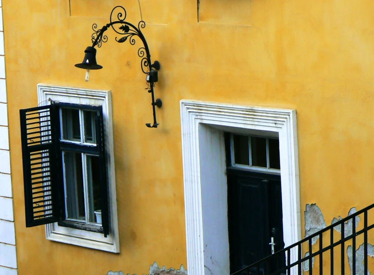 two windows that are next to a yellow building