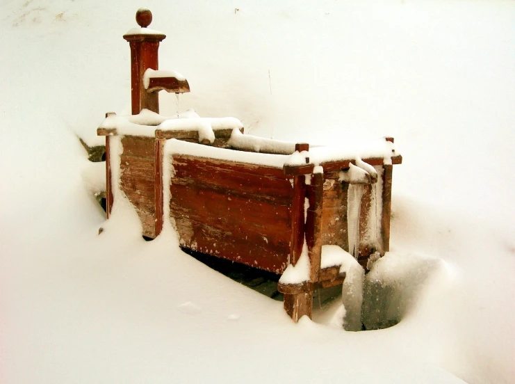 a pile of luggage covered with snow in the front yard