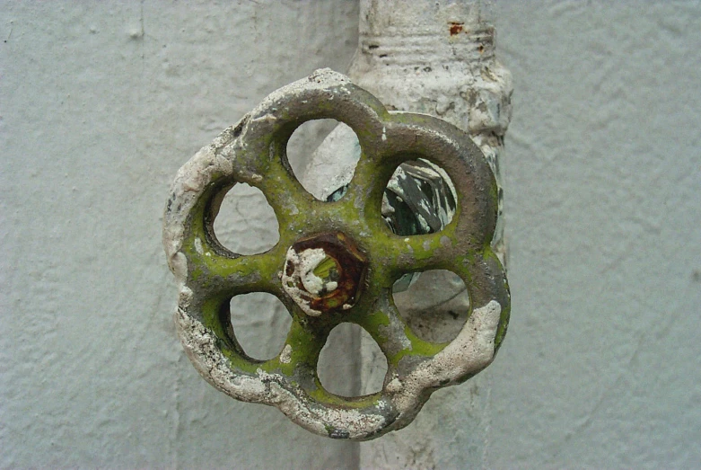 an old door knocker with four circles painted green